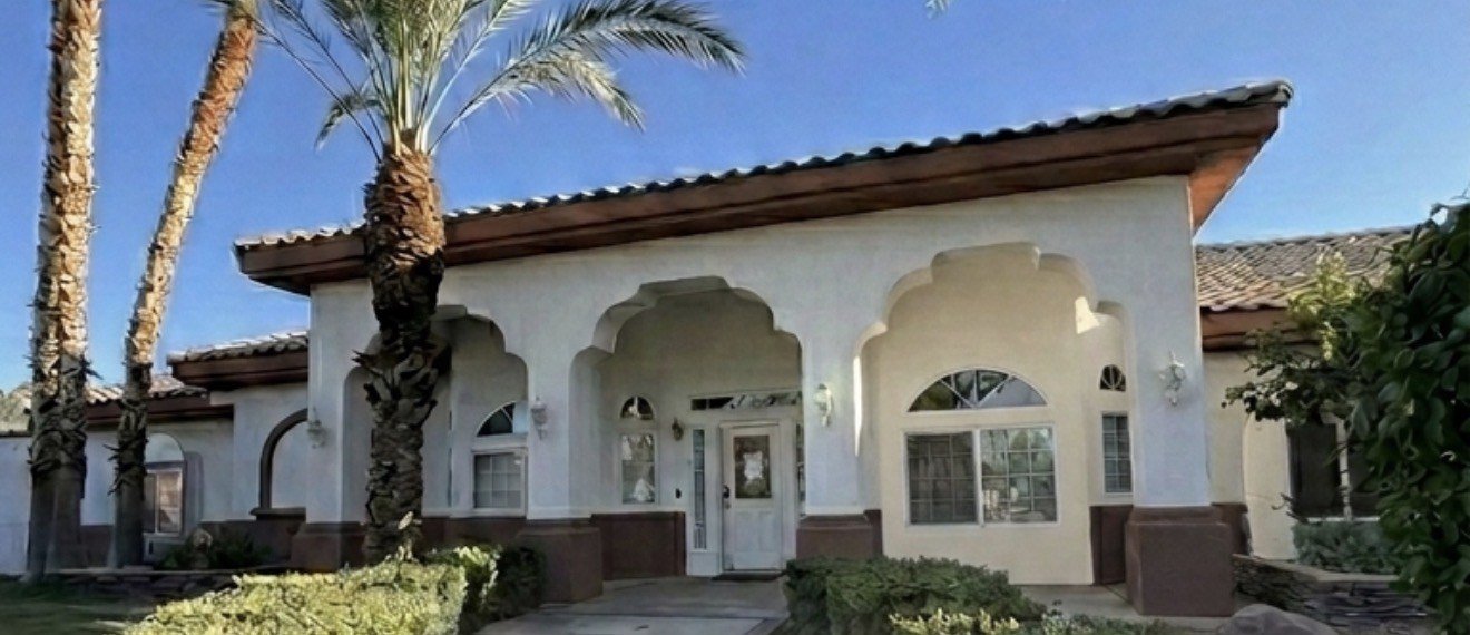 Front entrance of Durango Gardens with an arched porch and palm trees